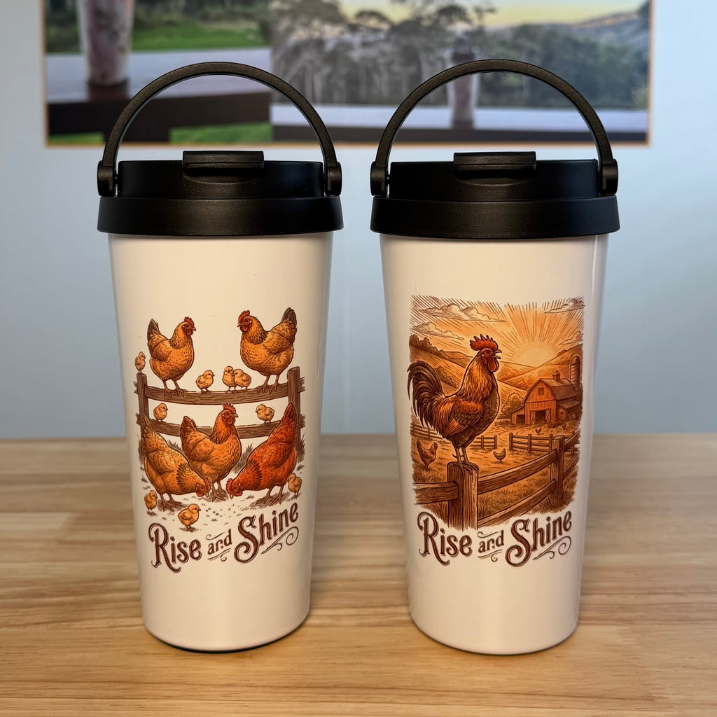Two white insulated carry mugs with black lids sit on a wooden table. Each mug has a different chicken farm illustration and the text 'Rise and Shine'.