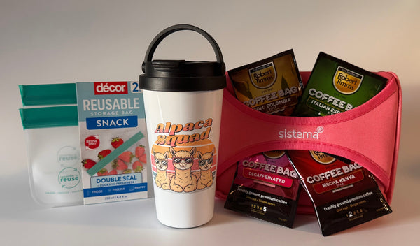 Reusable snack bag, coffee mug, and coffee bags in a pink holder on a light background