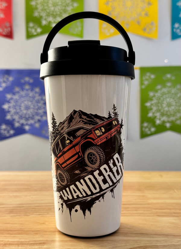 Travel mug with a design of an off-road vehicle and 'Wanderer' text on a wooden surface.
