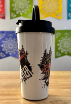 White tumbler with black lid featuring a graphic design of a truck and trees on a wooden surface with colorful flags in the background.