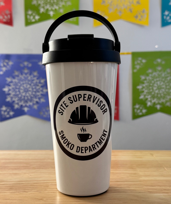 White tumbler with black lid on a wooden surface, featuring a 'Site Supervisor Smoko Department' logo.